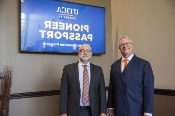 President Todd Pfannestiel and VP of Enrollment Management Eric Sykes stand in front of monitors announcing Pioneer Passport.